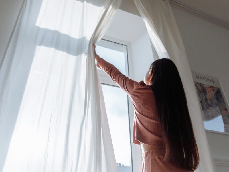 カーテンを開ける女性